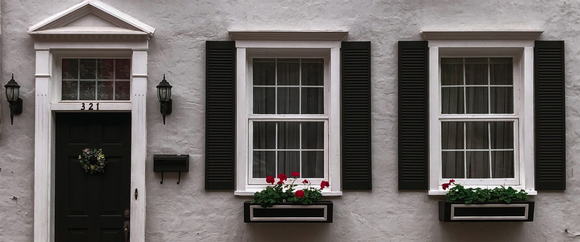 white facade of a house with black door